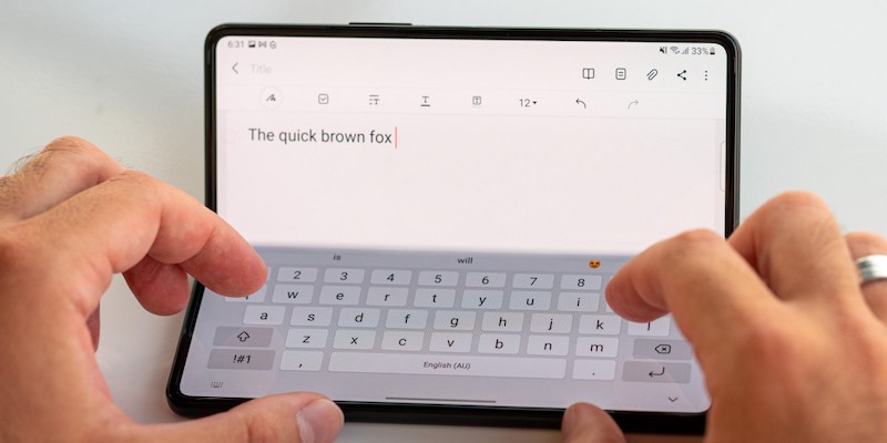 Samsung Galaxy Fold4 bent to 45º, with a document on the top half and a virtual keyboard on the bottom half